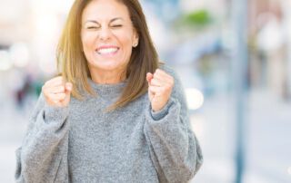 Frau ballt vor Freude die Fäuste – Freude über die bestandene Heilpraktikerprüfung